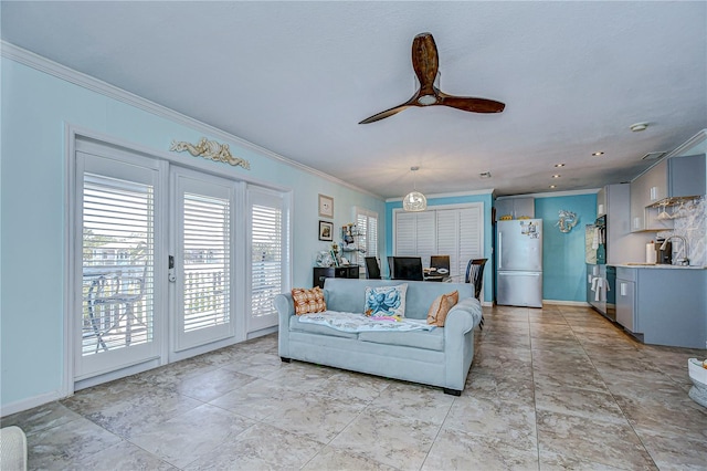 living room featuring ceiling fan, sink, and ornamental molding