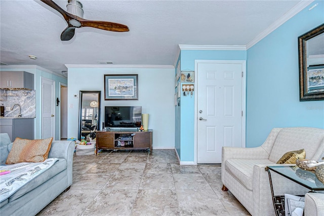 living room with ceiling fan, crown molding, and sink