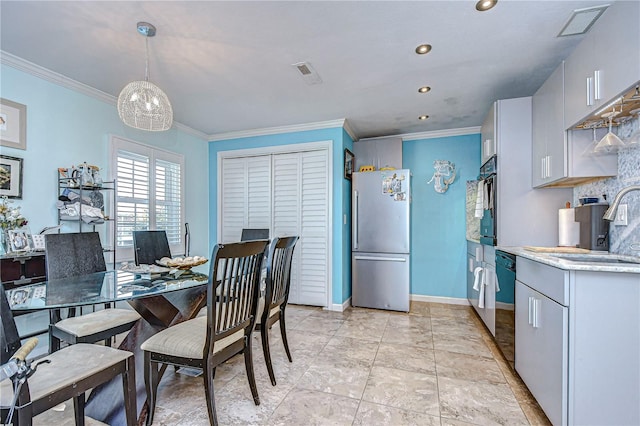 dining space featuring crown molding and sink