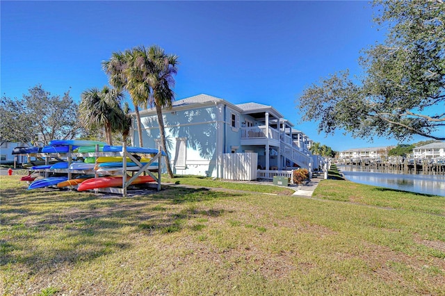 rear view of property featuring a water view and a yard