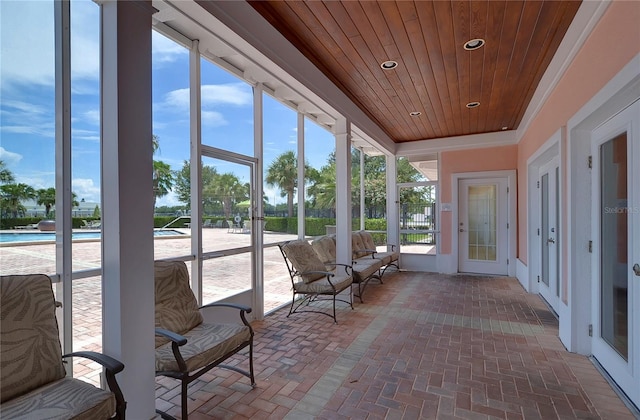 unfurnished sunroom featuring a healthy amount of sunlight and wooden ceiling