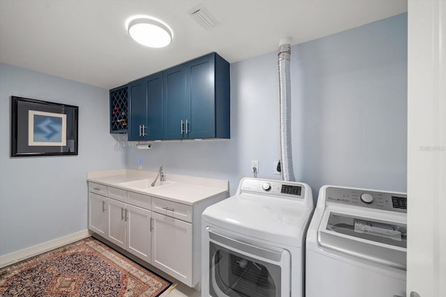 washroom with cabinets, sink, and washing machine and dryer