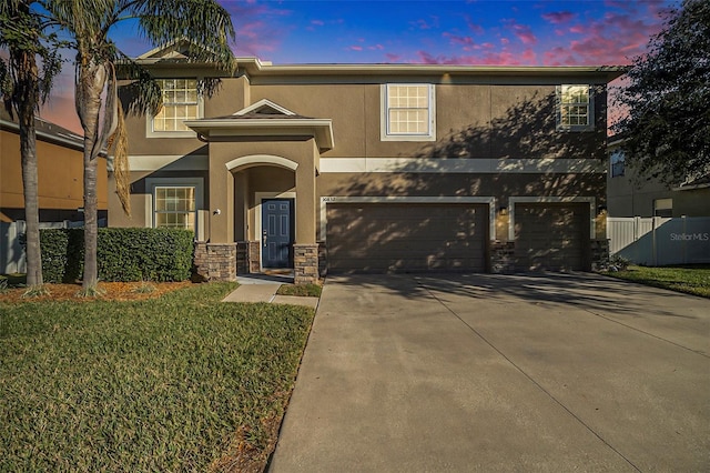 view of front of home with a garage and a yard