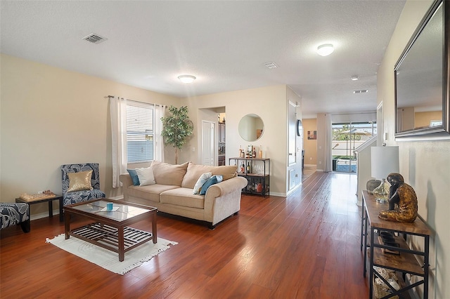 living room featuring dark hardwood / wood-style flooring and a textured ceiling