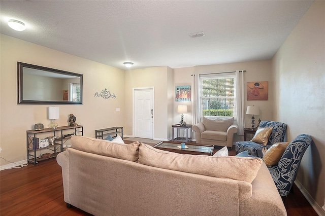 living room featuring a textured ceiling and dark hardwood / wood-style floors