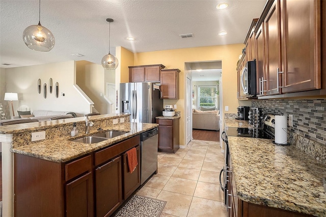 kitchen featuring sink, stainless steel appliances, an island with sink, pendant lighting, and light tile patterned floors