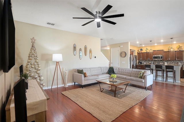 living room with ceiling fan and dark hardwood / wood-style floors