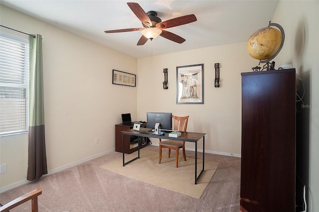 carpeted office with a textured ceiling and ceiling fan