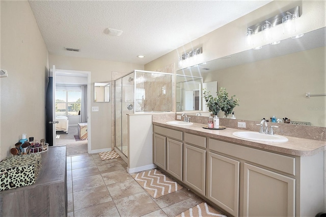 bathroom with vanity, a textured ceiling, and an enclosed shower