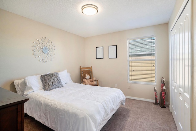 carpeted bedroom featuring a textured ceiling and a closet