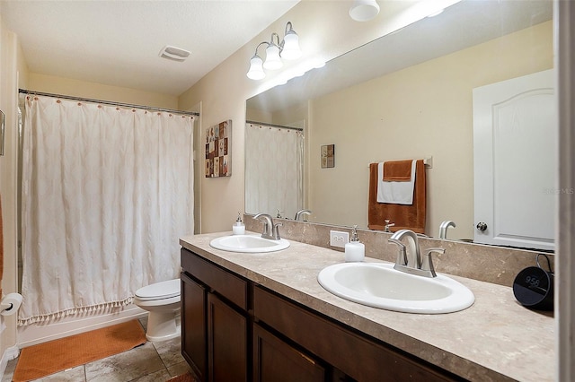 full bathroom with vanity, shower / bath combo, and toilet