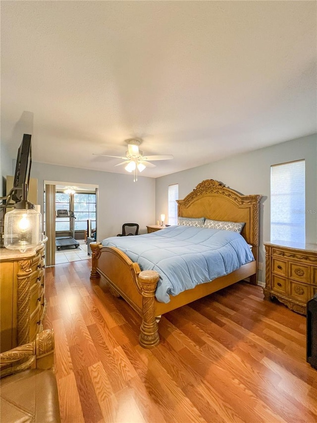 bedroom with ceiling fan, multiple windows, and light hardwood / wood-style flooring