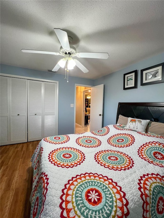 bedroom featuring a textured ceiling, ceiling fan, a closet, and hardwood / wood-style flooring