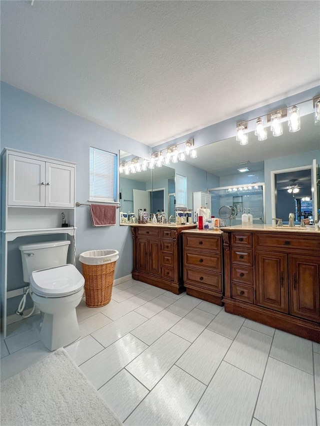 bathroom with toilet, tile patterned flooring, walk in shower, a textured ceiling, and vanity