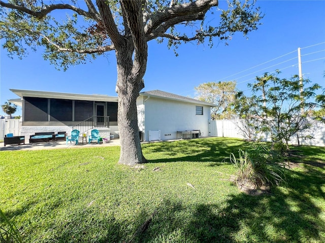 back of property featuring a sunroom, a lawn, and a patio