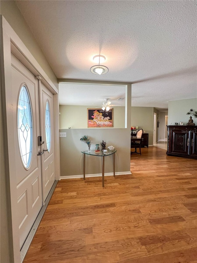 entrance foyer with a textured ceiling and light wood-type flooring