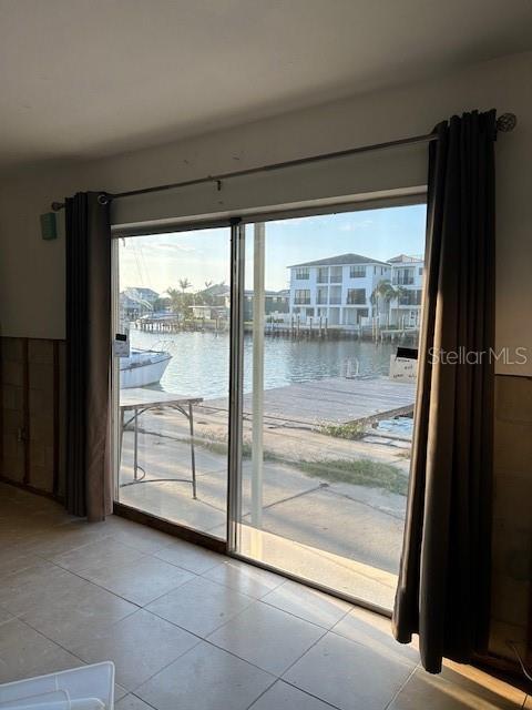 entryway featuring a wealth of natural light, tile patterned floors, and a water view