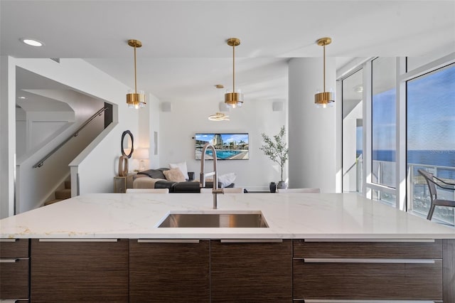 kitchen with dark brown cabinetry, sink, and decorative light fixtures