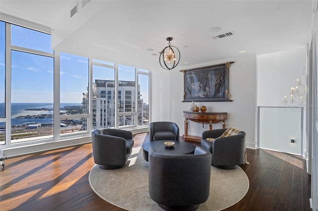 interior space with a water view, dark hardwood / wood-style floors, and an inviting chandelier