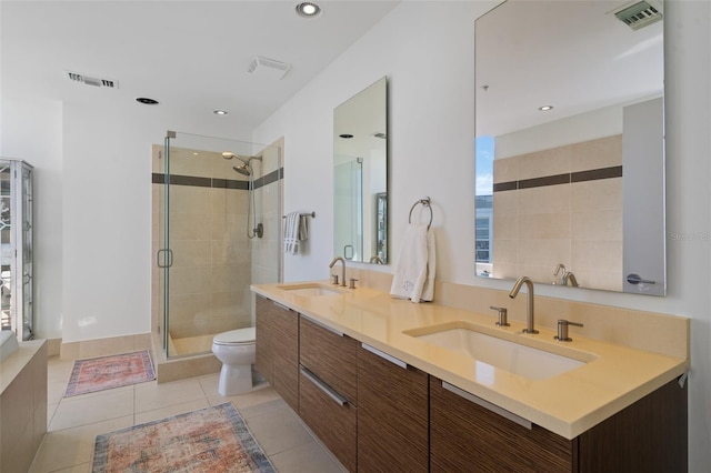 bathroom with tile patterned floors, vanity, a shower with shower door, and toilet