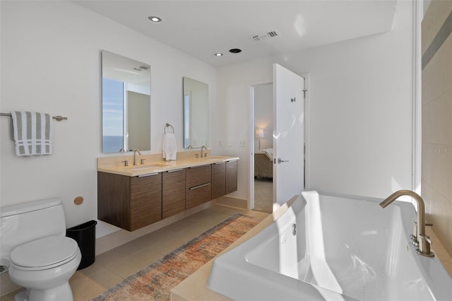 bathroom featuring vanity, a washtub, tile patterned flooring, and toilet