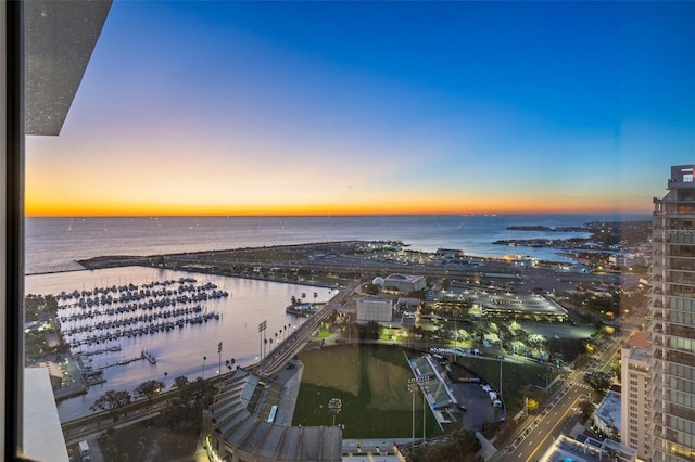 aerial view at dusk featuring a water view