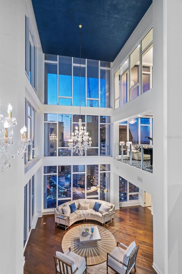 living room featuring a towering ceiling and hardwood / wood-style flooring