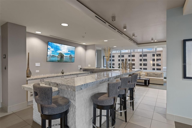 bar featuring light stone counters and light tile patterned flooring