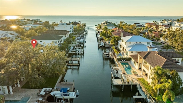 aerial view at dusk featuring a water view