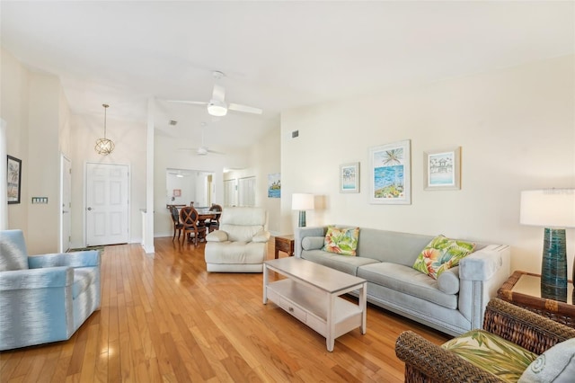 living room featuring ceiling fan, high vaulted ceiling, and light wood-type flooring