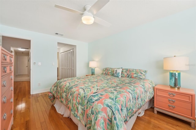 bedroom featuring ceiling fan, light hardwood / wood-style floors, and a closet