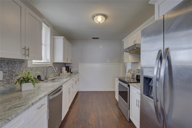 kitchen featuring sink, dark wood-type flooring, stainless steel appliances, light stone counters, and white cabinets