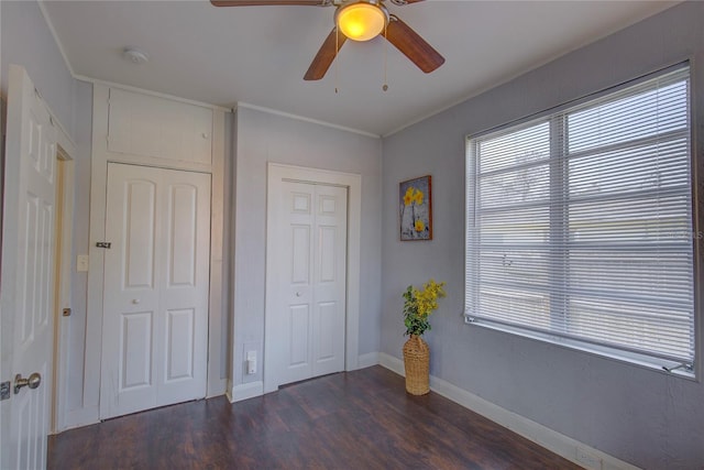 unfurnished bedroom featuring ceiling fan, ornamental molding, and dark hardwood / wood-style flooring