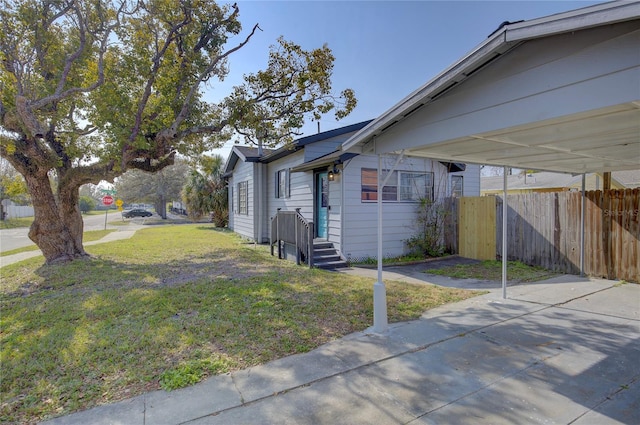 view of side of home featuring a carport and a yard