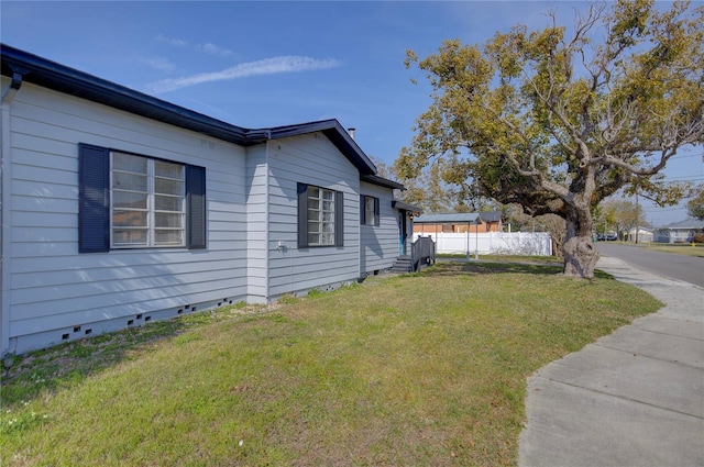 view of home's exterior featuring a yard, crawl space, and fence