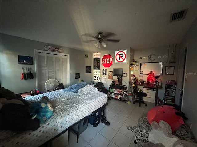 tiled bedroom featuring ceiling fan and a closet