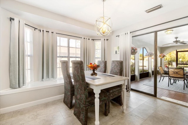 tiled dining space featuring ceiling fan with notable chandelier