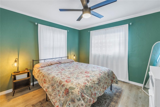 bedroom with ceiling fan, crown molding, and light hardwood / wood-style floors