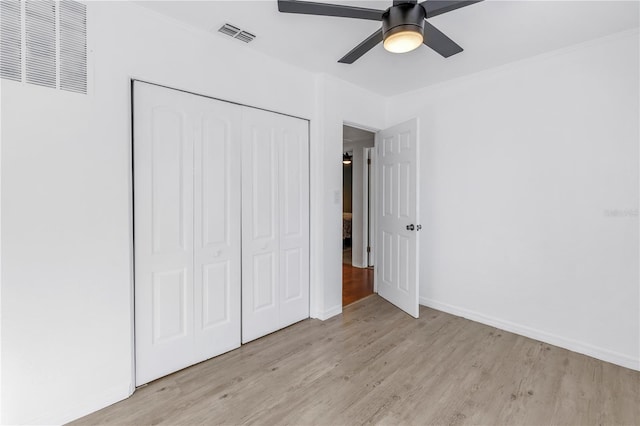 unfurnished bedroom featuring a closet, light hardwood / wood-style flooring, and ceiling fan