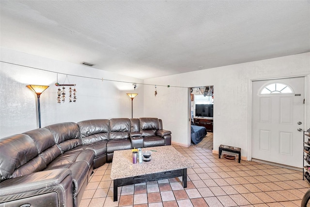 living room featuring light tile patterned flooring and a textured ceiling