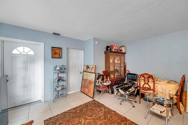 entrance foyer with light tile patterned floors and a textured ceiling