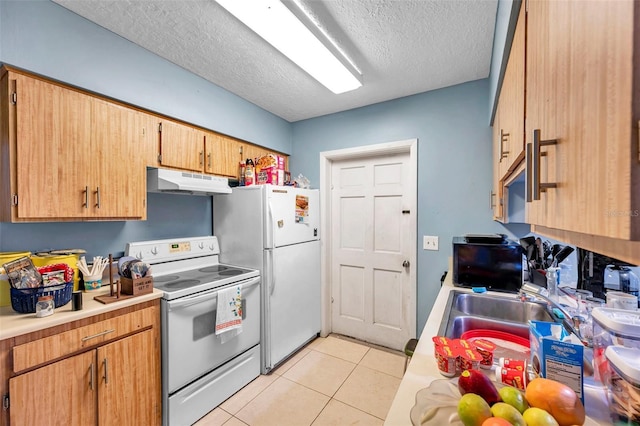 kitchen featuring light tile patterned flooring, sink, white appliances, and a textured ceiling