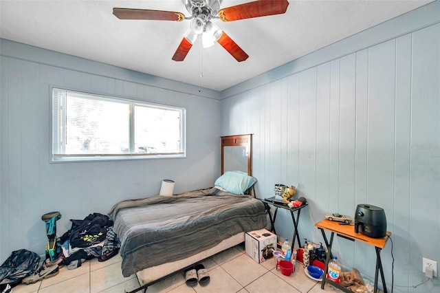 tiled bedroom featuring ceiling fan and wooden walls