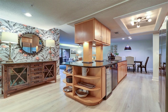 kitchen featuring light hardwood / wood-style floors, hanging light fixtures, a tray ceiling, and sink