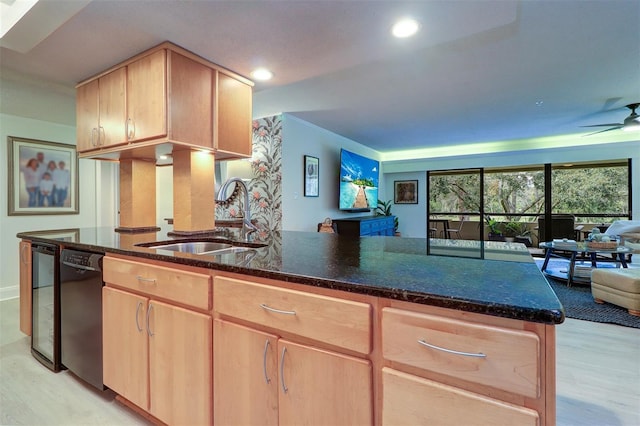 kitchen featuring dishwasher, light brown cabinets, dark stone countertops, and sink