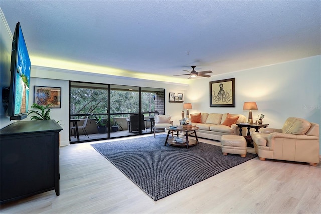 living room with ceiling fan, a textured ceiling, and hardwood / wood-style flooring