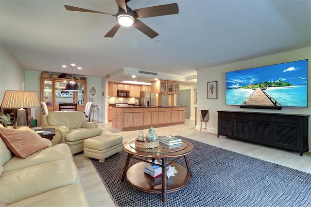 living room featuring light hardwood / wood-style flooring and ceiling fan