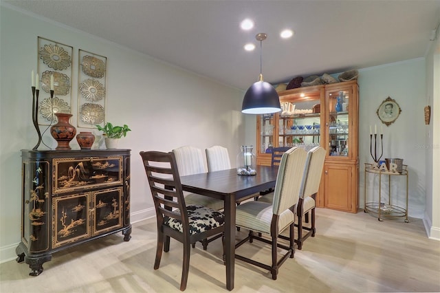 dining space featuring light hardwood / wood-style floors and crown molding