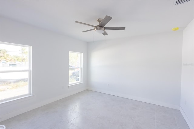 tiled empty room featuring plenty of natural light and ceiling fan