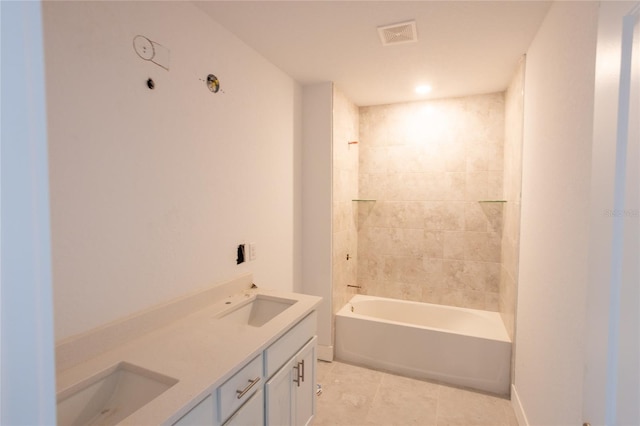 bathroom with tile patterned floors, vanity, and tiled shower / bath combo